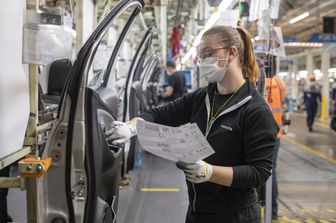 Un'operaia in catena di montaggio