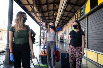 Passeggeri alla stazione di Bologna alla ripresa dei trasporti nella Fase 2