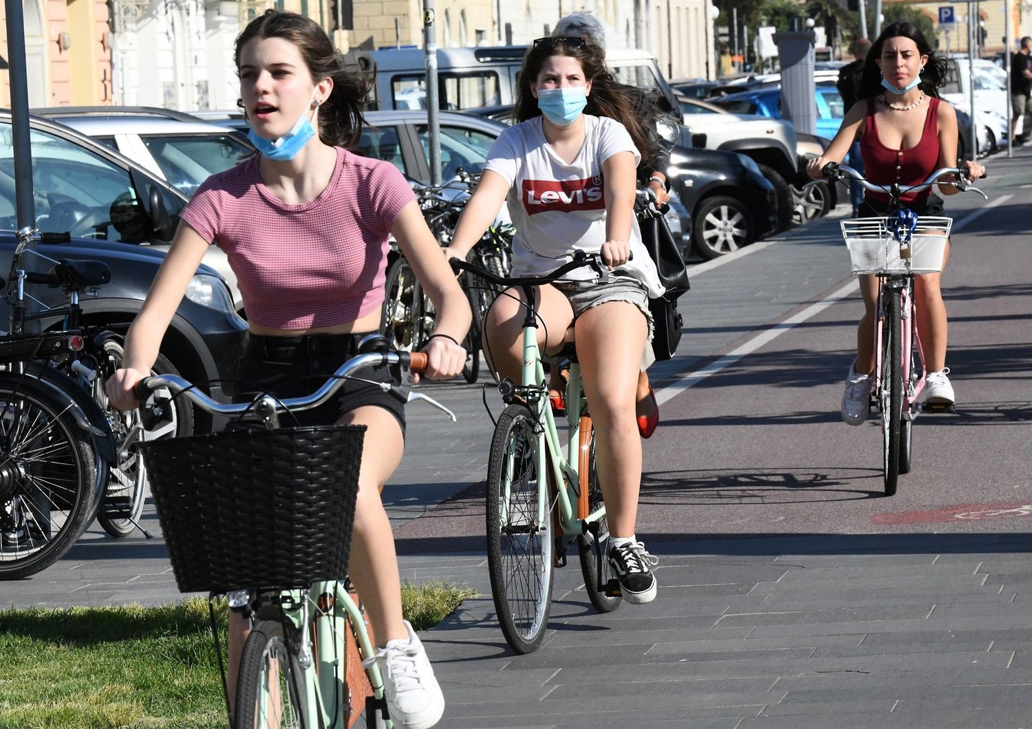 Viareggio, giovani in bicicletta con la mascherina&nbsp;sul lungomare