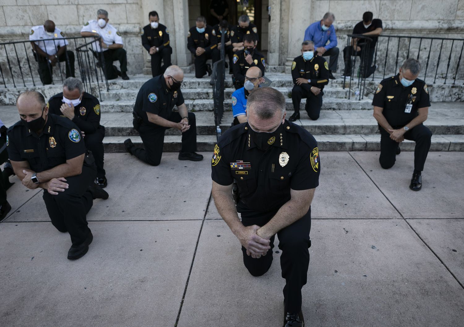 Agenti di polizia di Coral Gables, nella contea di Maiami Dade, pregano con i manifestanti