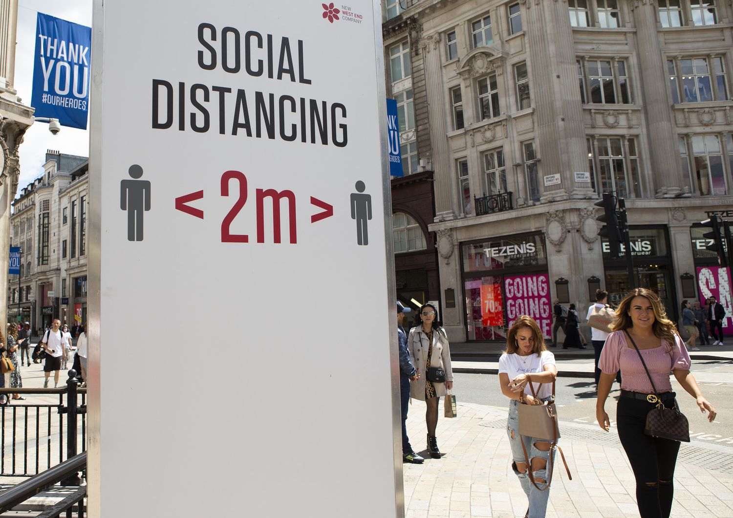 Un cartello nel centro di Londra invita a rispettare il distanziamento sociale per limitare il contagio da coronavirus