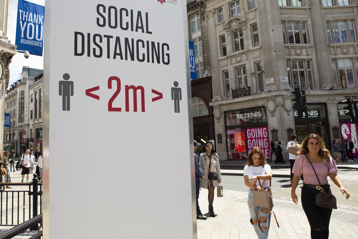 Un cartello nel centro di Londra invita a rispettare il distanziamento sociale per limitare il contagio da coronavirus