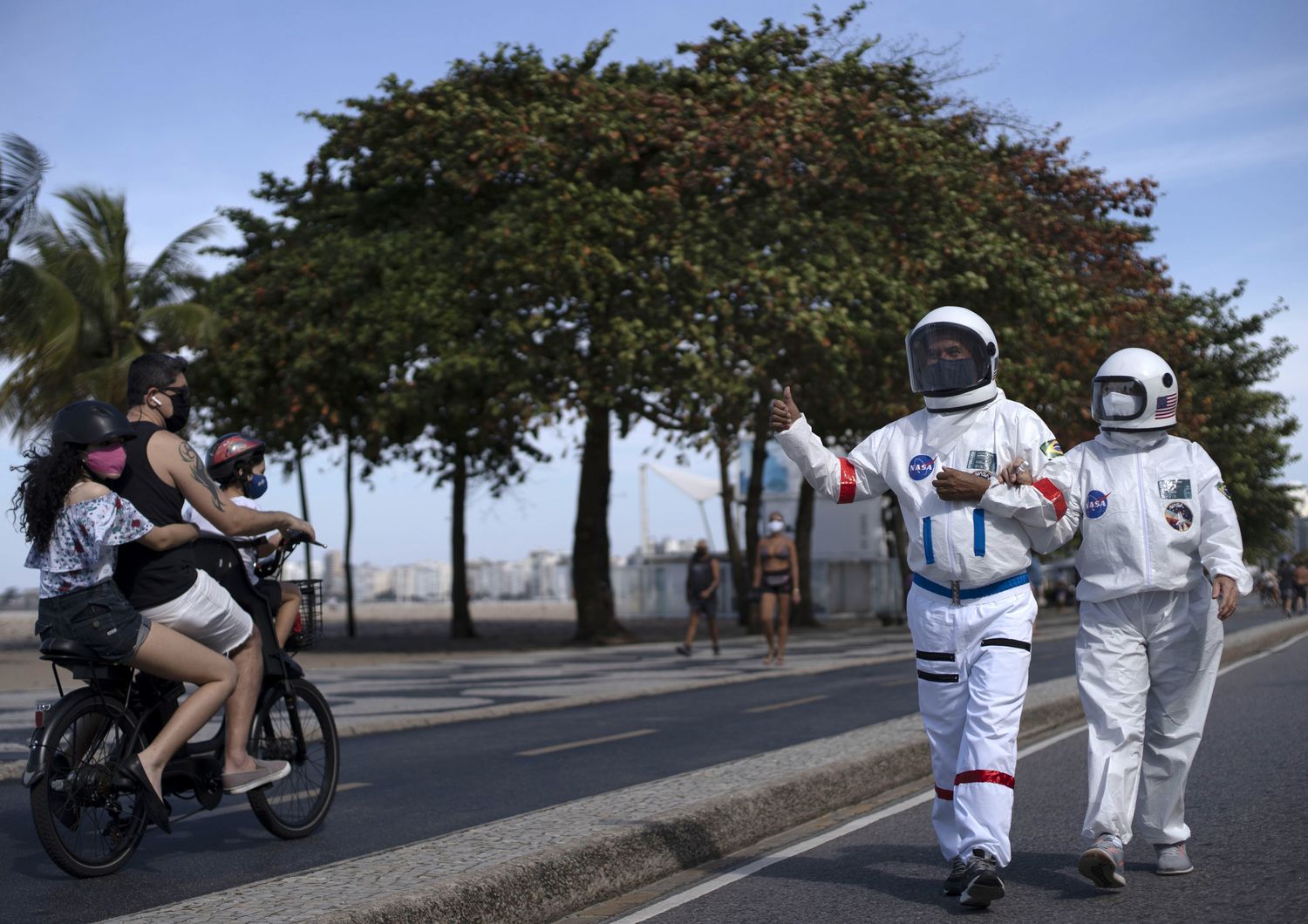 La coppia di brasiliani che va in giro con le tute da astronauta per non contrarre il coronavirus