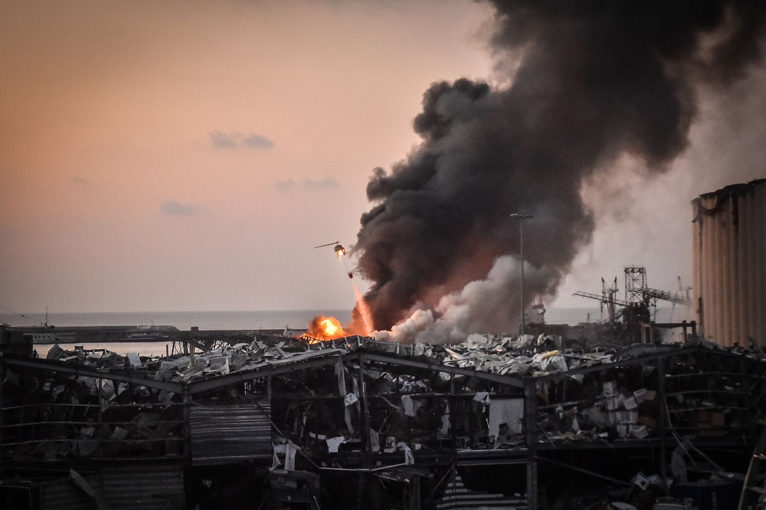 Un elicottero spegne le fiamme al porto di Beirut