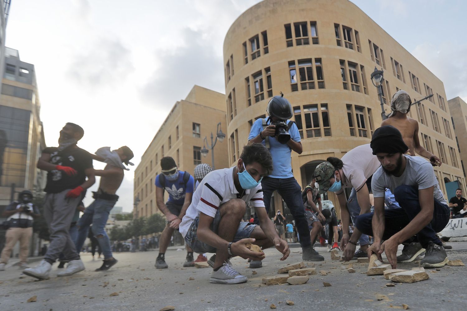 Manifestanti raccolgono sassi da lanciare durante la manifestazione a Beirut