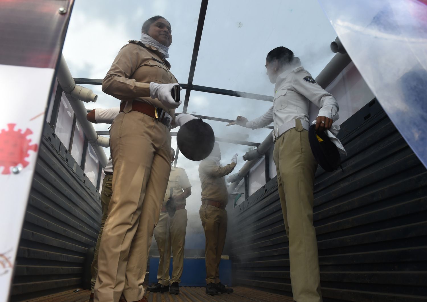 Poliziotte indiane in un impianto di sanificazione