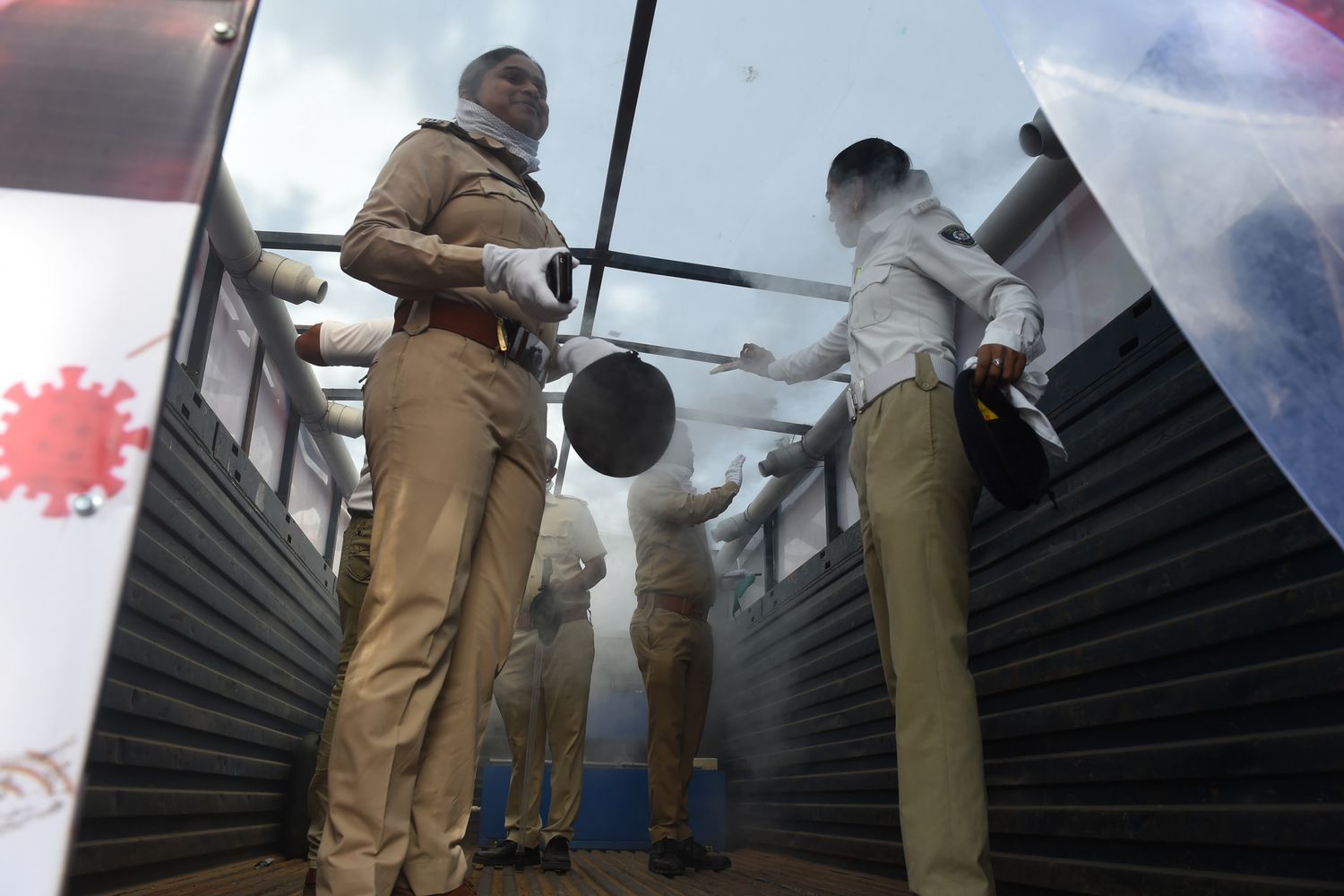 Poliziotte indiane in un impianto di sanificazione