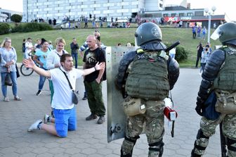 Manifestante davanti alle forze di sicurezza a Minsk, durante una protesta contro i brogli elettorali