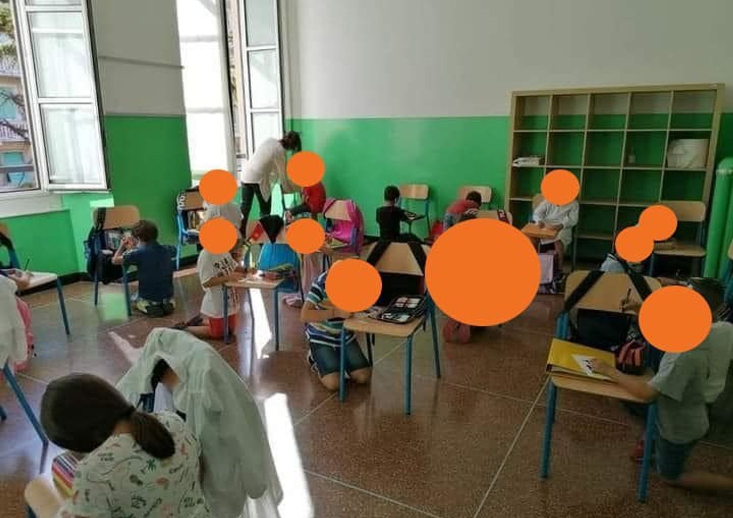 scuola Genova senza banchi bambini scrivono in ginocchio
