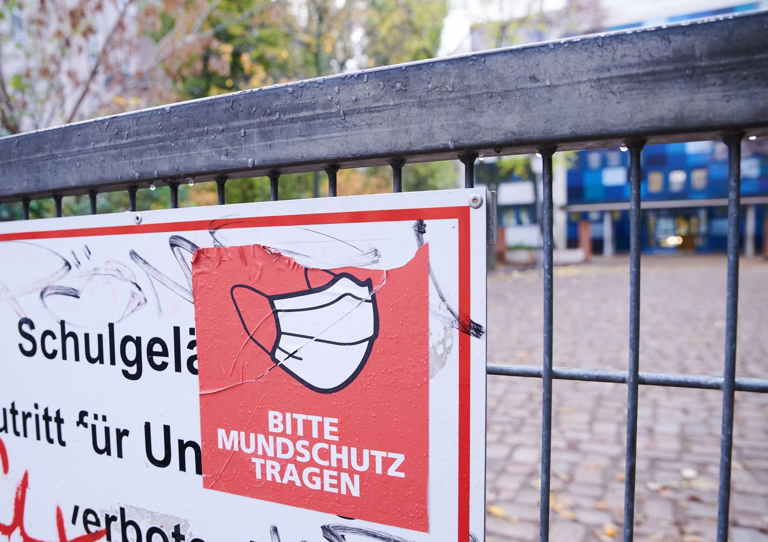 Un cartello fuori da una scuola tedesca per invitare all'uso della mascherina