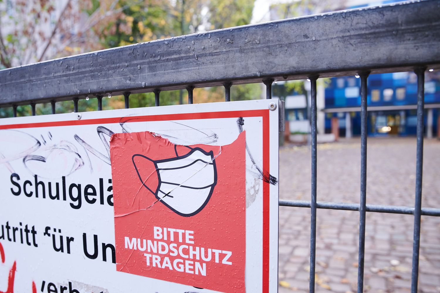 Un cartello fuori da una scuola tedesca per invitare all'uso della mascherina