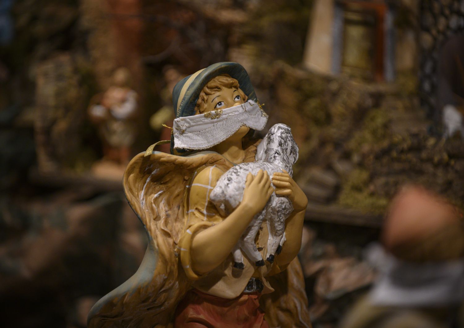Una statuina del presepe del duomo di Torino con la mascherina