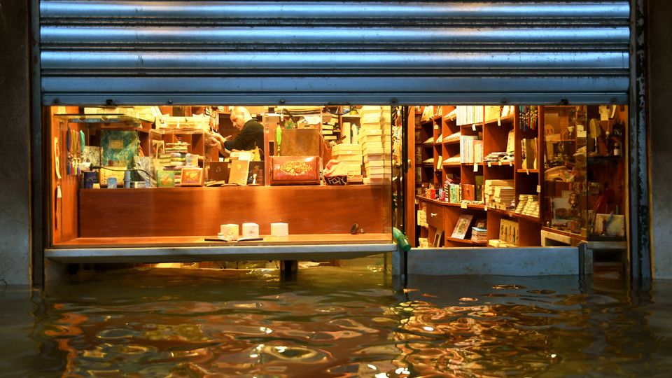 Le difese approntate da un commerciante di piazza San Marco per impedire all'acqua alta di invadere il suo negozio