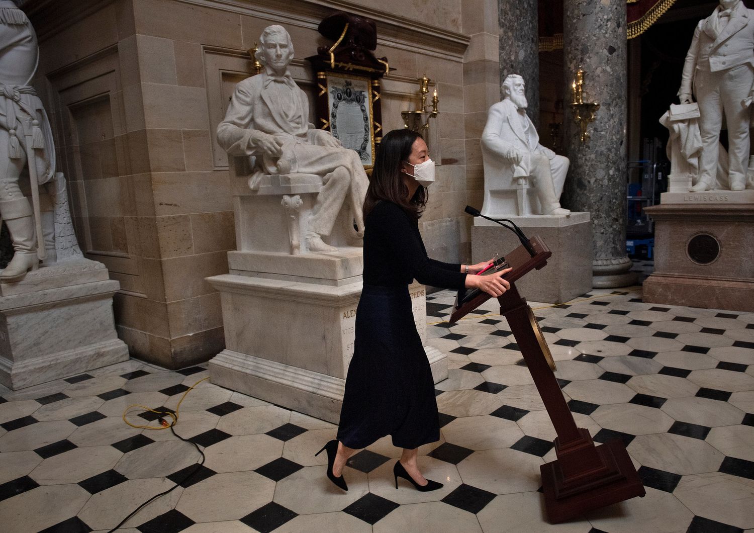 Un'addetta della Camera riporta in Aula il leggio di Nancy Pelosi