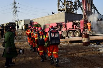 Una squadra di soccorritori si dirige verso l'ingresso della miniera di Qixia, in Cina