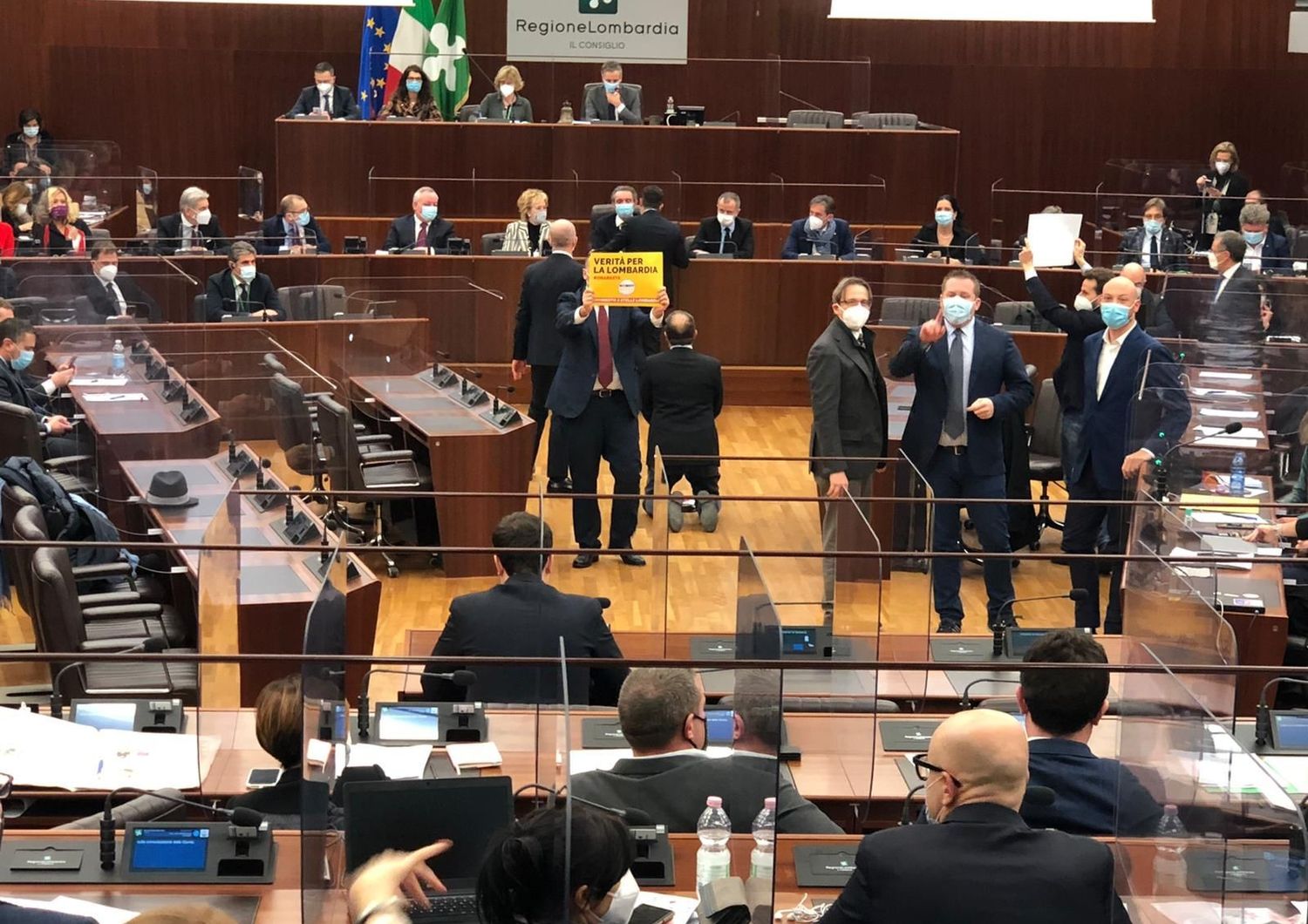 Il consigliere di +Europa, Michele Usuelli, inginocchiato 'polemicamente' davanti al governatore Fontana
