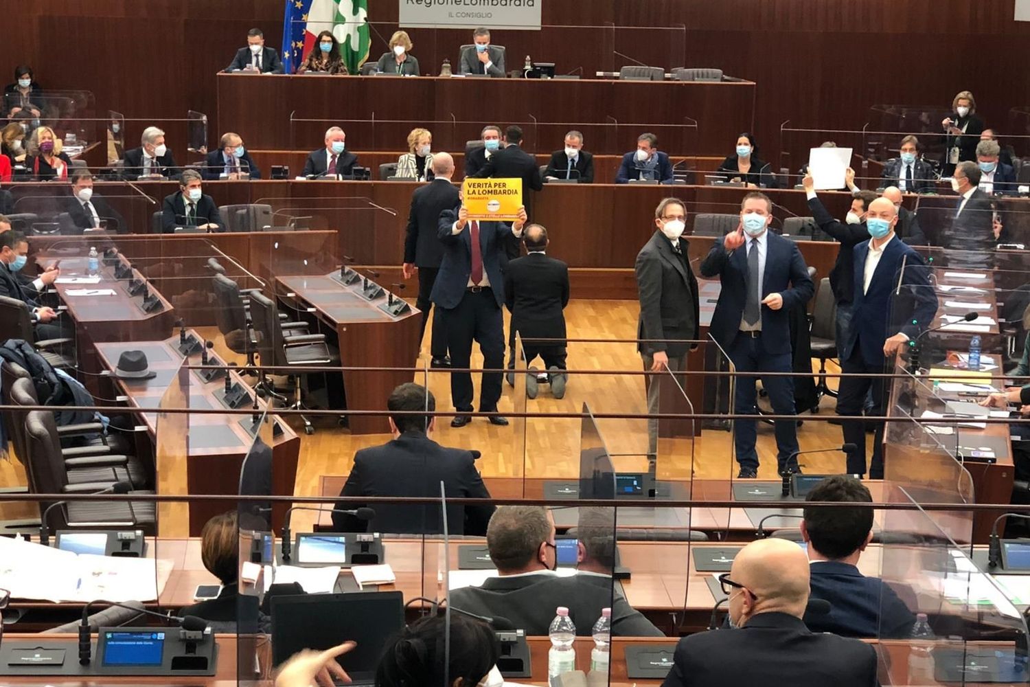 Il consigliere di +Europa, Michele Usuelli, inginocchiato 'polemicamente' davanti al governatore Fontana