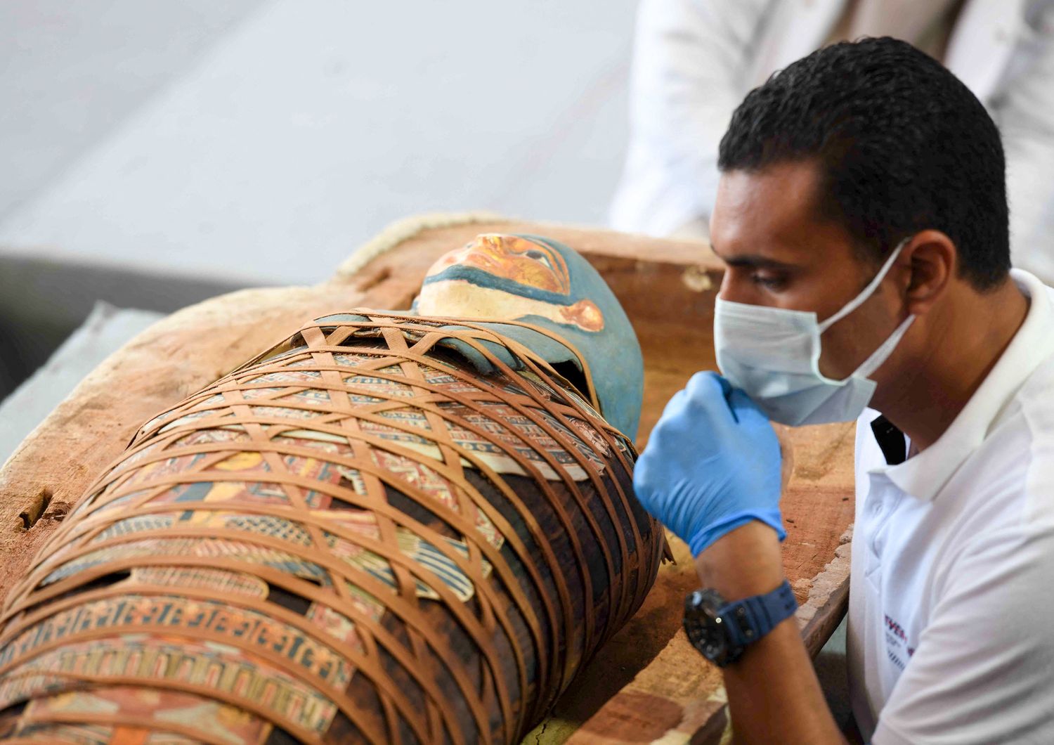 Un archeologo ispeziona una mummia ritrovata nella necropoli di Saqqara, vicino al Cairo, nel novembre 2020