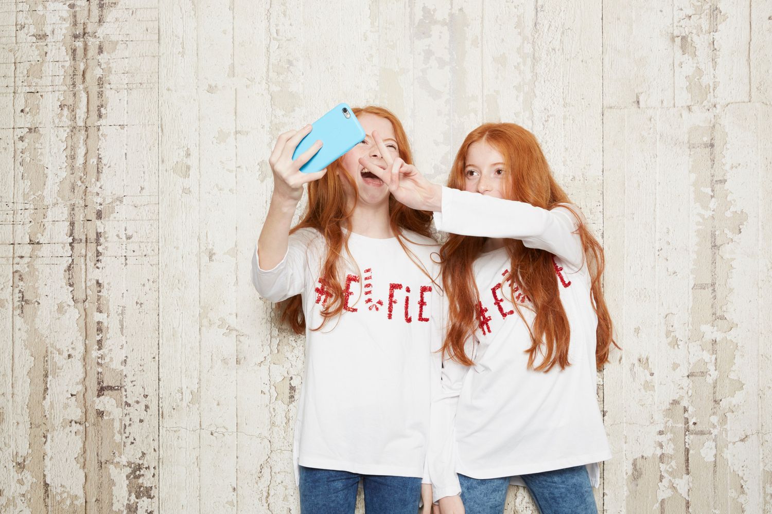 Due bambine giocano con uno smartphone