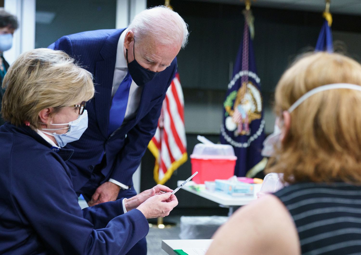 Joe Biden osserva una dose di vaccino prima che venga inoculato in un centro per veterani