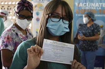 Una donna mostra il certificato vaccinale in Honduras