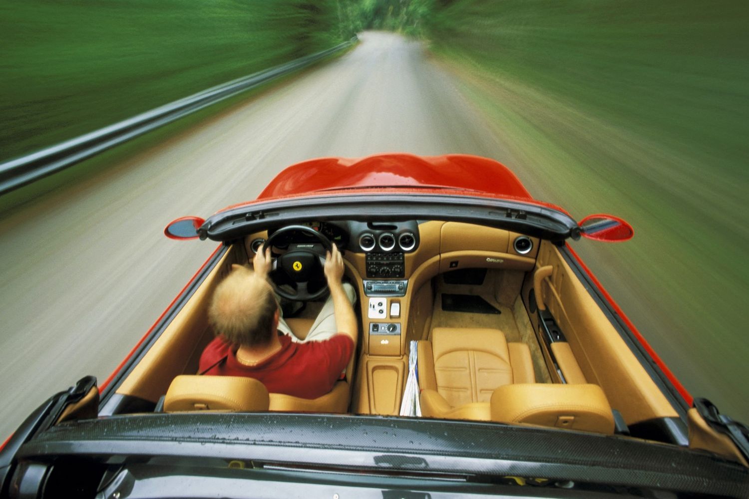 Un uomo alla guida di una Ferrari