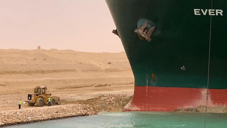 Una ruspa al lavoro per liberare la portacontainer incagliata nel Canale di Suez