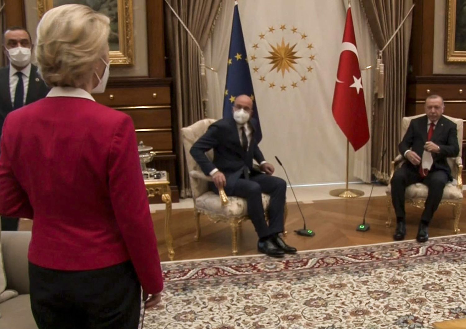 Ursula von der Leyen in piedi mentre Charles Michel e Recep Erdogan sono seduti