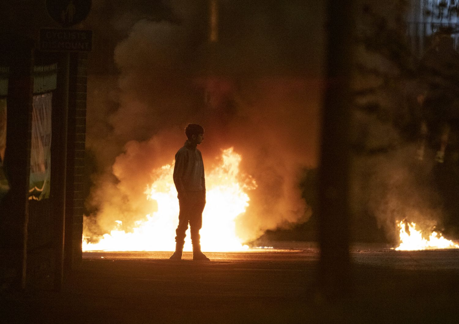 Un ragazzo guarda le fiamme causate dalla rivolta avvenuta nell'aprile 2021 a Newtownabbey, a nord di Belfast, in Irlanda del Nord