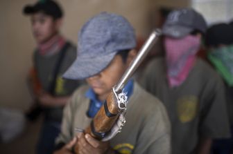 Un bambino con un fucile giocattolo si addestra alla guerriglia anti-narcos