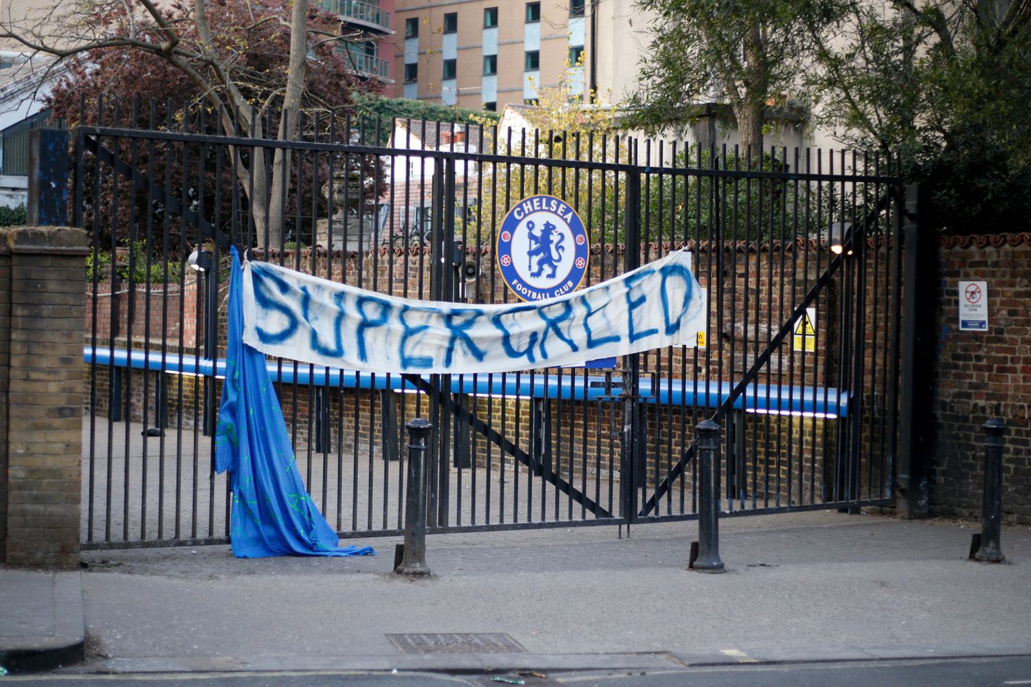 Uno striscione con la scritta 'super-avidit&agrave;' appeso al cancello del Chelsea