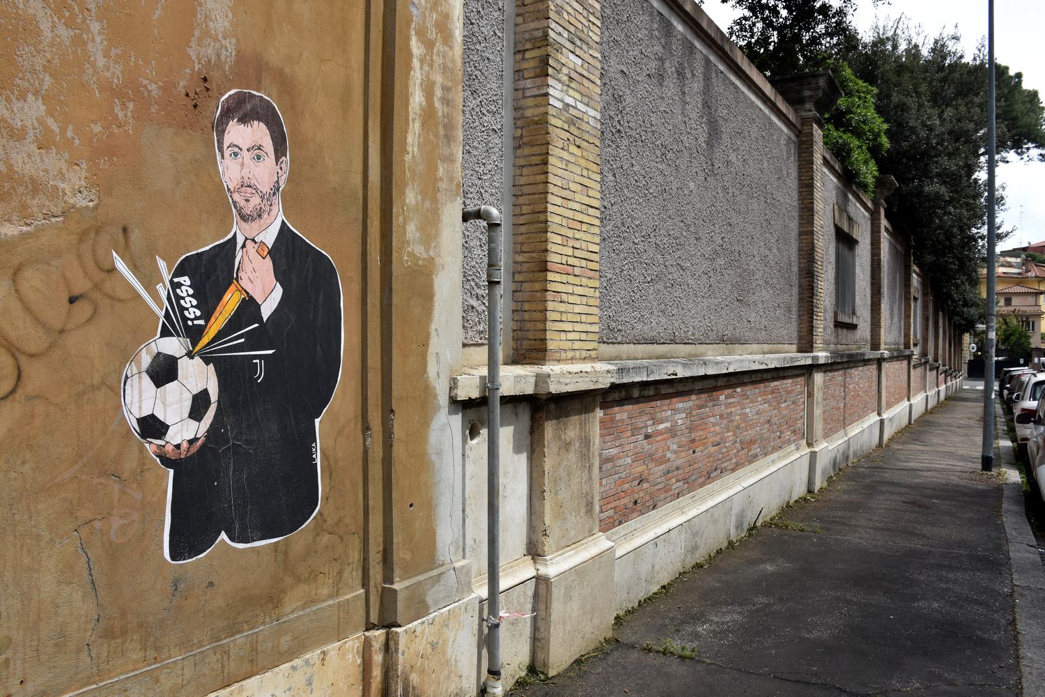 Murales che raffigura Andrea Agnelli mentre &quot;buca&quot; un pallone a Roma