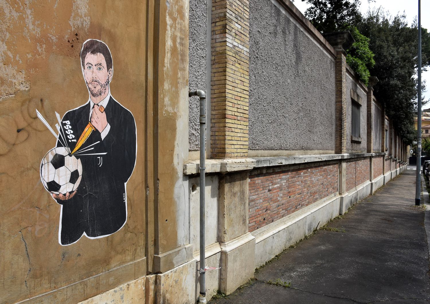 Murales che raffigura Andrea Agnelli mentre &quot;buca&quot; un pallone a Roma