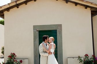 Il bacio di due sposini davanti alla chiesa dov'&egrave; stato celebrato il loro matrimonio