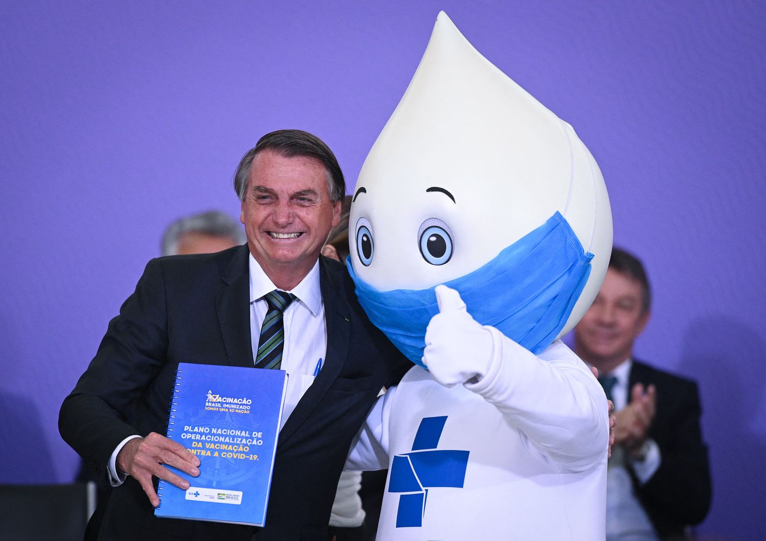 Il presidente brasiliano, Bolsonaro, con la mascotte scelta per la campagna vaccinale anti Covid nel Paese