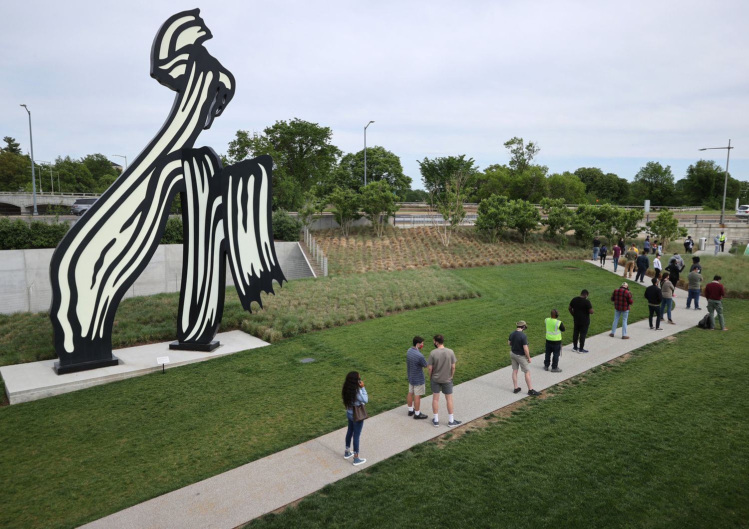 Persone in fila per il vaccino vicino a una scultura di&nbsp;Roy Lichtenstein a Washington