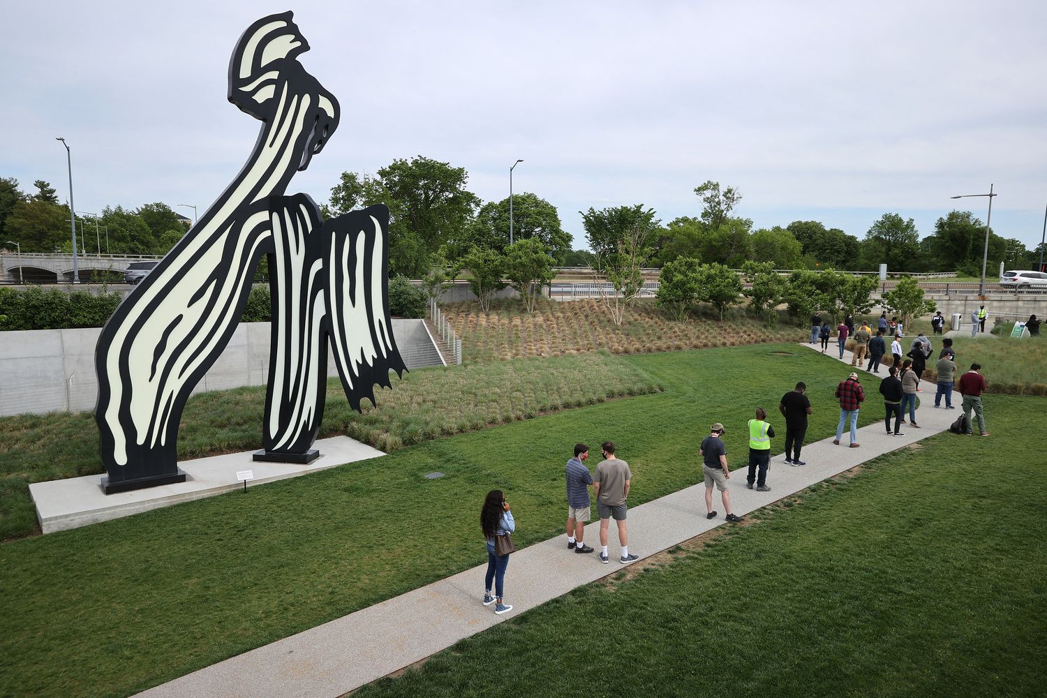 Persone in fila per il vaccino vicino a una scultura di&nbsp;Roy Lichtenstein a Washington