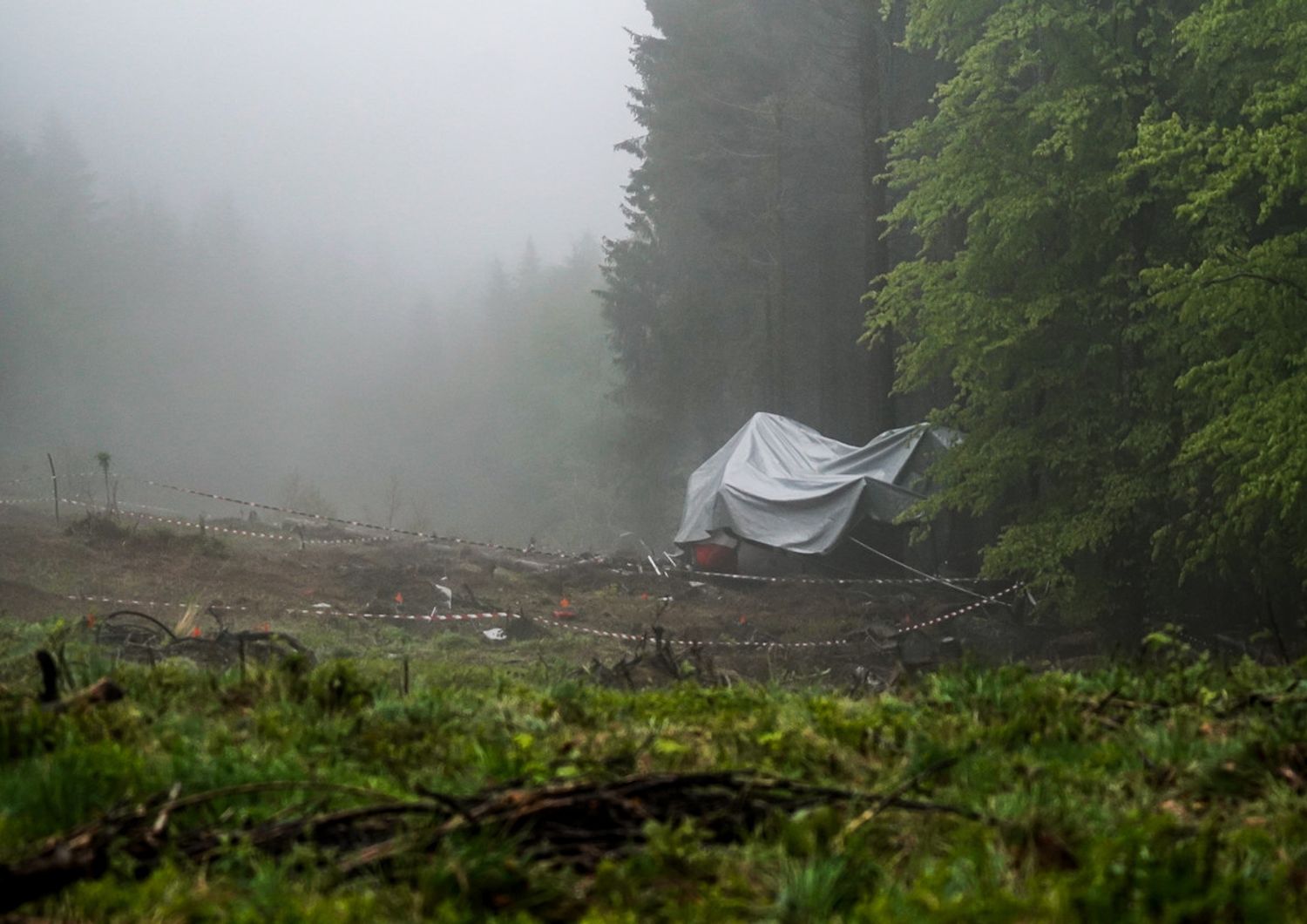 La carcassa della cabina della funivia di Mottarone coperta da un telo