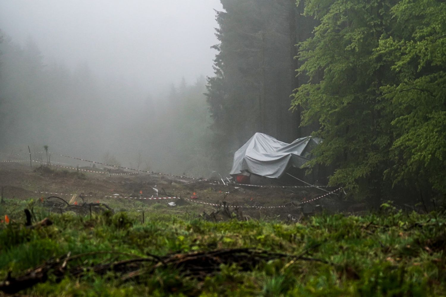 La carcassa della cabina della funivia di Mottarone coperta da un telo