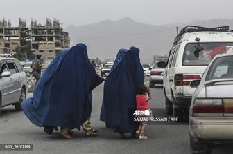 Donne afghane che indossano il burqa salgano su un taxi a Kabul&nbsp;