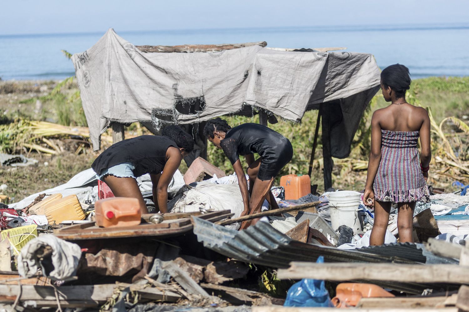 Haitiani e quello che rimane della loro abitazione dopo il terremoto