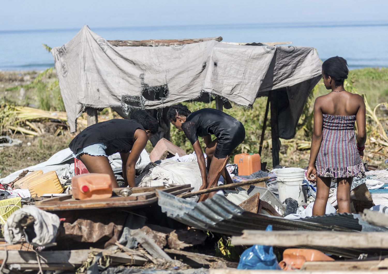 Haitiani e quello che rimane della loro abitazione dopo il terremoto
