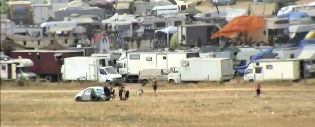 Decine di camper e roulotte accampati di fronte al lago di Mezzano