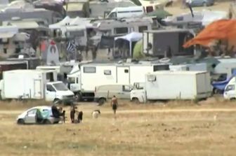 Decine di camper e roulotte accampati di fronte al lago di Mezzano