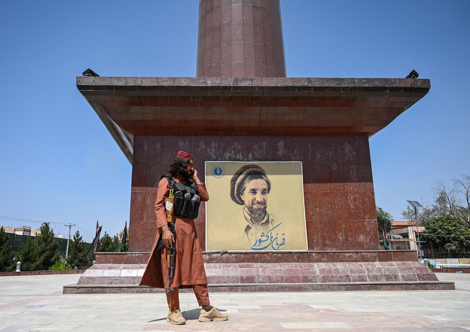 Un guerrigliero talebano davanti a un ritratto del comandante Massoud, il leone del Panshir, a Kabul