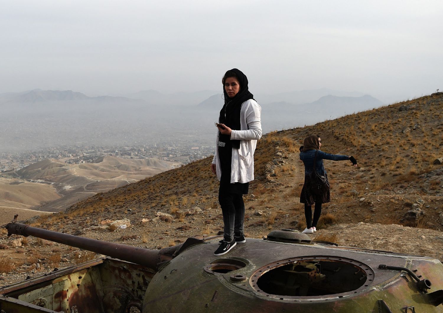 Una ragazza sulla carcassa di un carro armato russo in Afghanistan