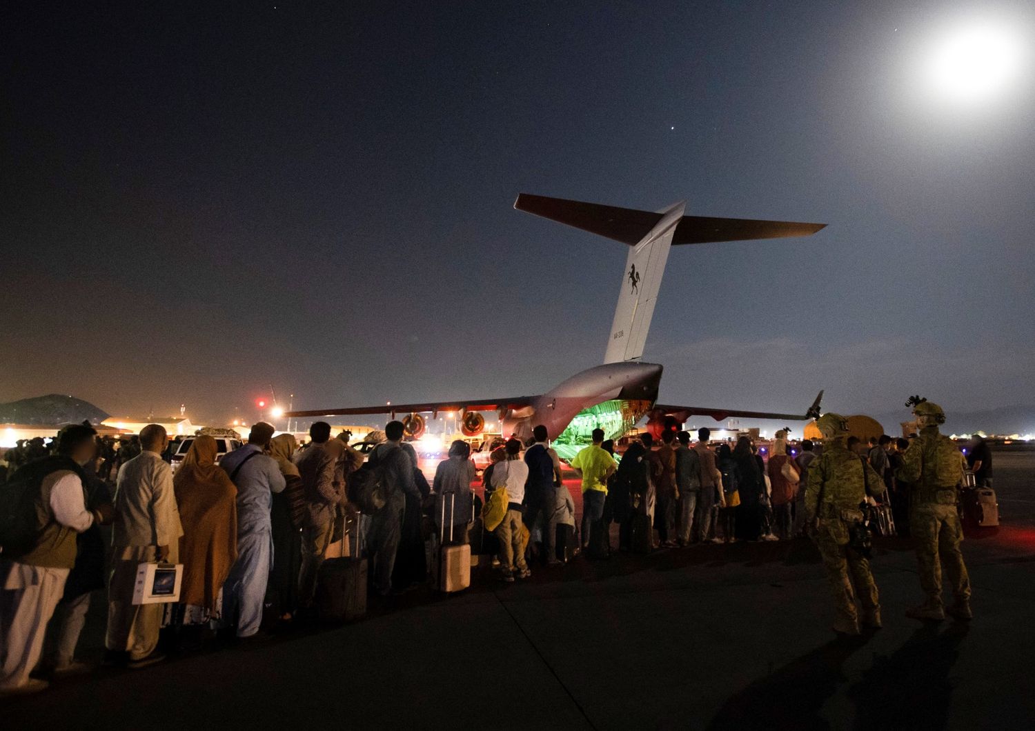 Afghani in attesa di essere imbarcati su un aereo militare australiano all'aeroporto di Kabul