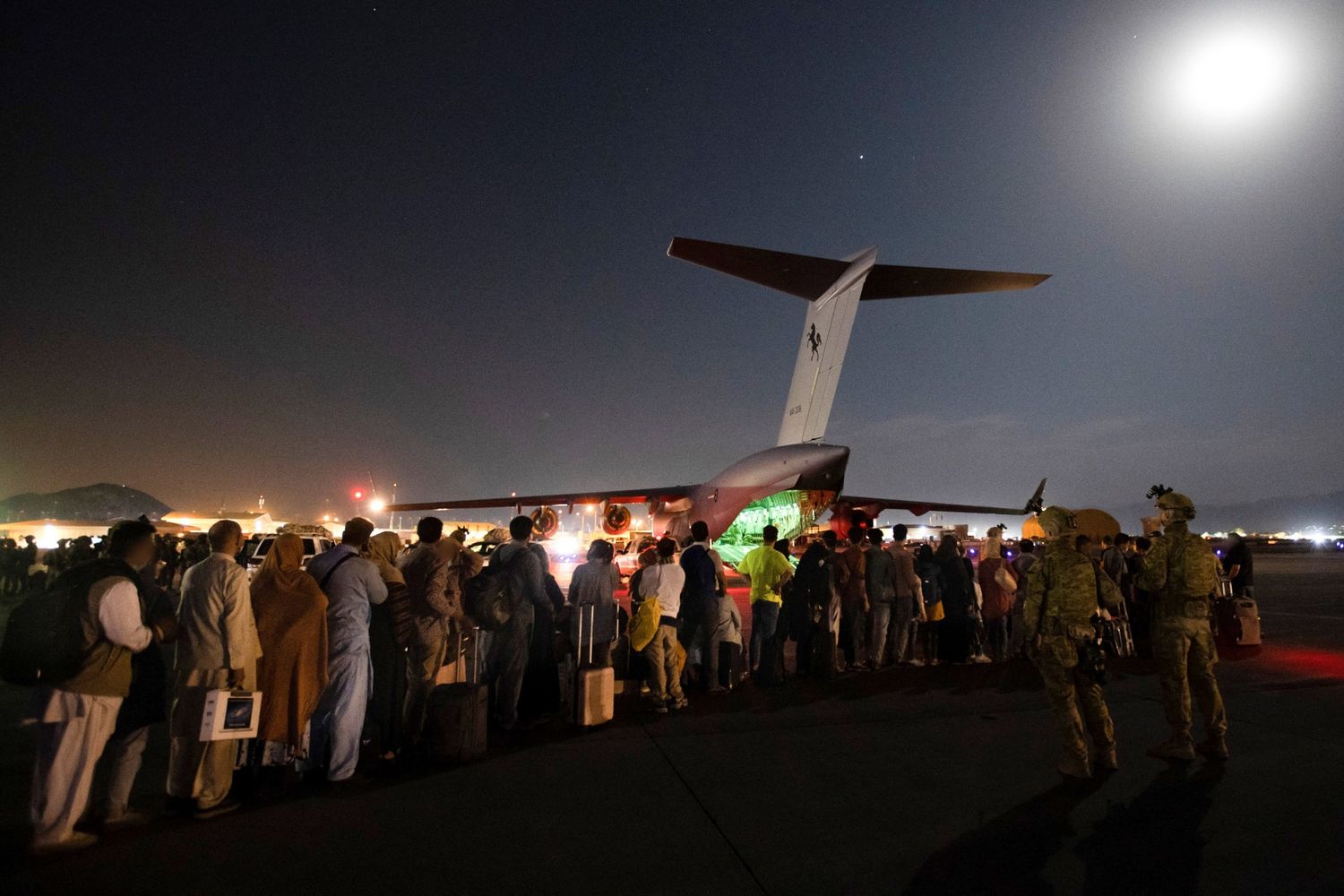 Afghani in attesa di essere imbarcati su un aereo militare australiano all'aeroporto di Kabul