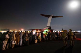 Afghani in attesa di essere imbarcati su un aereo militare australiano all'aeroporto di Kabul