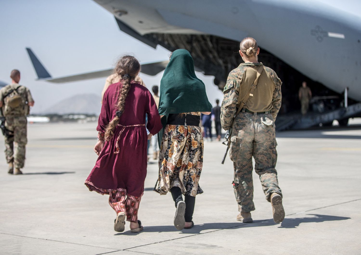 La marine Nicola Gee mentre scorta due donne afghane su un aereo nello scalo di Kabul
